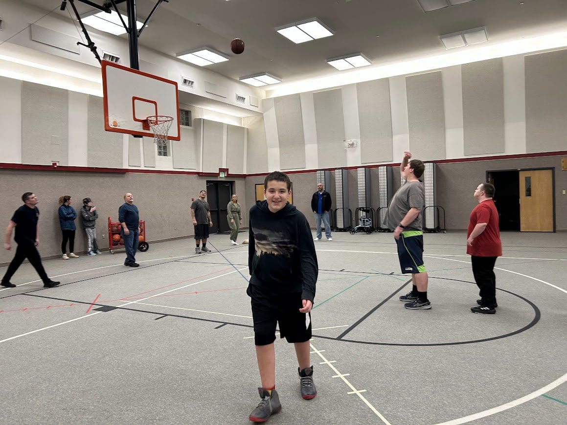 Smiling youth walking on indoor basketball court